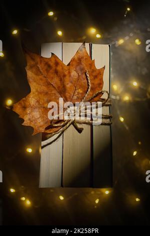 Autumn Dry Leaf On Closed Books Tied Up From Above Stock Photo