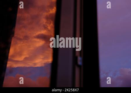 Dawn sky with colorfull clouds. Sunset landscape through the window with reflection on it Stock Photo