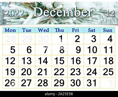 beautiful calendar for December 2022 with picture of pine branch covered snow Stock Photo