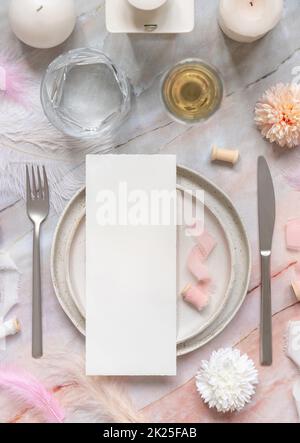 Wedding Table place with a card near pink flowers, feathers and silk ribbons, menu mockup Stock Photo