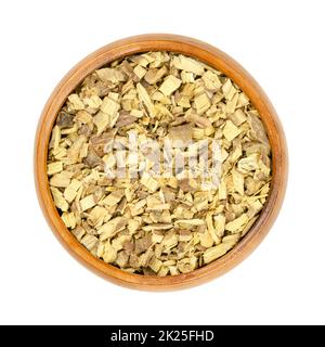 Liquorice root chips, dried cut root of licorice, in wooden bowl Stock Photo