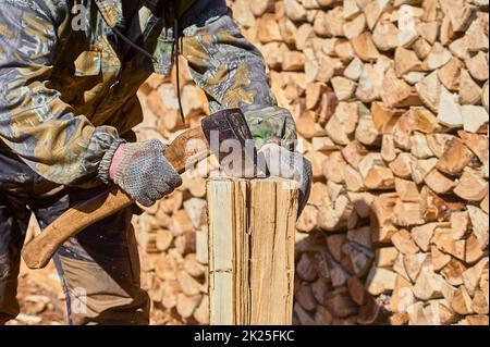 chopping firewood with a chopper close-up on a sunny day Stock Photo