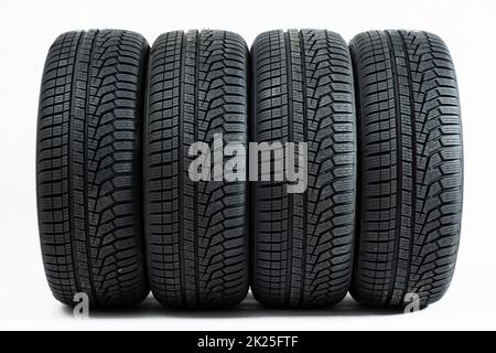 Four wheels with winter tires from front view isolated on white background. Stock Photo
