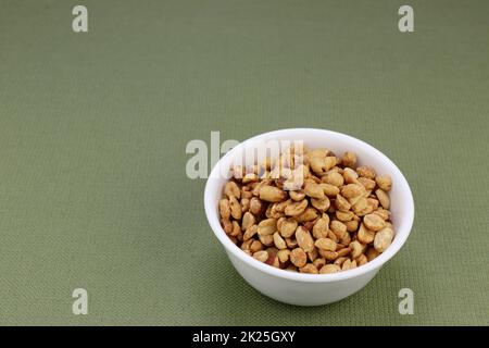 Round White Bowl Filled with Dry Roasted Salted Peanuts Snack. Stock Photo