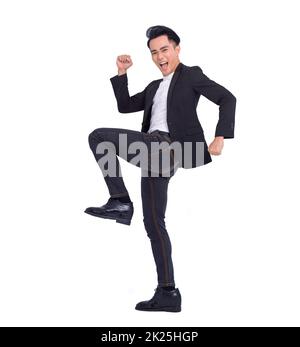 Excited young successful business man jumping and dancing Stock Photo