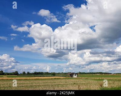 Beautiful shot of a big white clouds and little house Stock Photo