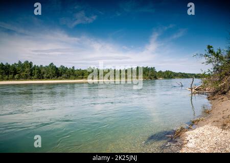 A beautiful shot of a reflective lake in a green landscape on a blue sky background Stock Photo