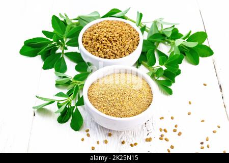 Fenugreek in two bowls with leaves on light board Stock Photo
