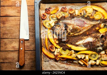 Baked gilthead fish in fruit. Stock Photo
