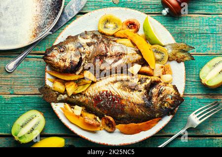 Baked gilthead fish in fruit. Stock Photo