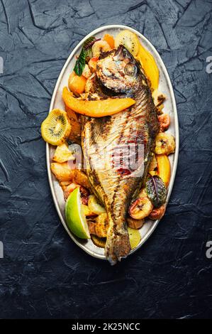 Baked gilthead fish in fruit. Stock Photo
