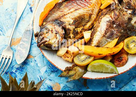 Baked gilthead fish in fruit. Stock Photo