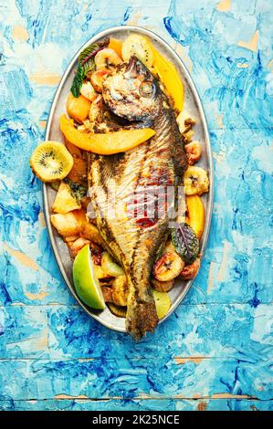 Baked gilthead fish in fruit. Stock Photo