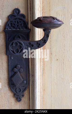 The historic old handle on the wooden doors