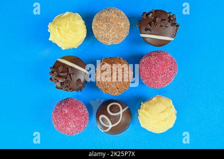 Chocolate pralines top view stock images. Chocolate candies on a light blue background. Chocolate frame top view. Square-shaped  chocolate pralines background Stock Photo
