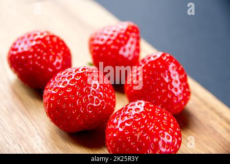 Strawberries on a cutting board. Black background Stock Photo