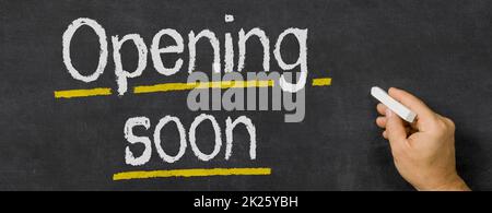 Text written on a blackboard - Opening soon Stock Photo