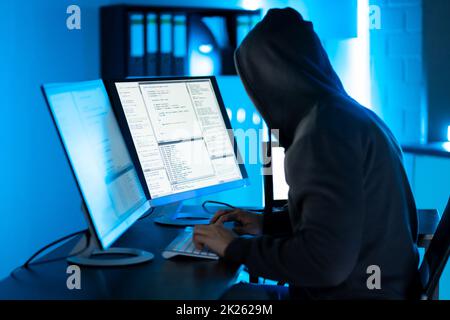 Hacker Using Computer To Write Exploit Stock Photo