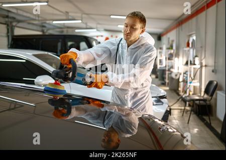 Professional car service worker polishing painted surface Stock Photo