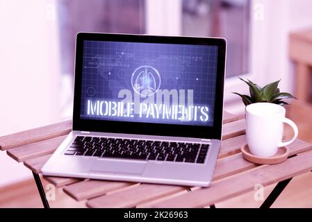 Inspiration showing sign Mobile Payments. Internet Concept financial transaction processed through a smartphone Laptop Resting On A Table Beside Coffee Mug And Plant Showing Work Process. Stock Photo