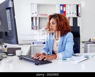 Focused on the job at hand. a young businesswoman working on her desktop computer. Stock Photo