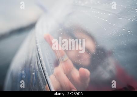 little girl holding a transparent umbrella and pointing with her finger Stock Photo