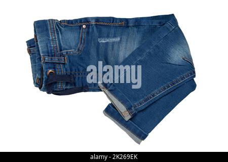 Blue jeans isolated. Closeup of a folded trendy stylish dark blue denim pants or trousers for boys isolated on a white background. Kids summer and autumn fashion. Front view. Stock Photo