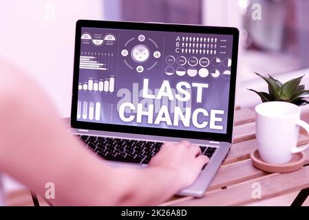Conceptual display Last Chance. Concept meaning a final opportunity given to a person with an uncertain outcome Hand Typing On Laptop Beside Coffe Mug And Plant Working From Home. Stock Photo