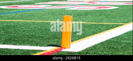 Orange pylon marking the end zone for a football game on q green turf field. Stock Photo