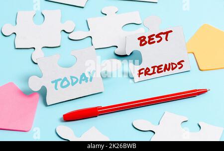 Text caption presenting Best Friends. Word for A person you value above other persons Forever buddies Building An Unfinished White Jigsaw Pattern Puzzle With Missing Last Piece Stock Photo