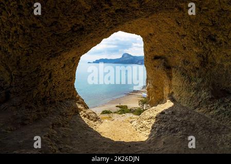 Sea view from a small cave on the slope of the coastal mountain Aeolian harp. Cape Alchak, Sudak, Crimea. Stock Photo