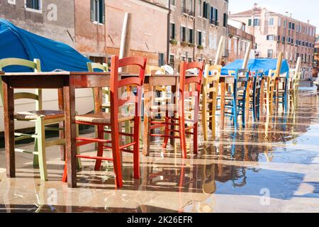 Colorful chairs in a row along Venetian canal Stock Photo