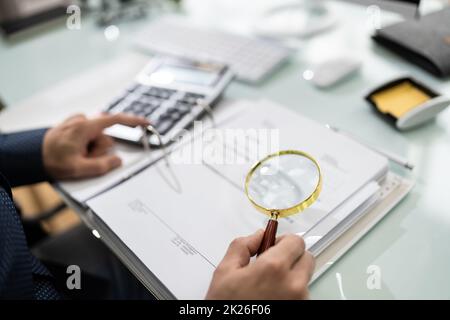 Auditor Using Magnifying Glass For Audit Stock Photo
