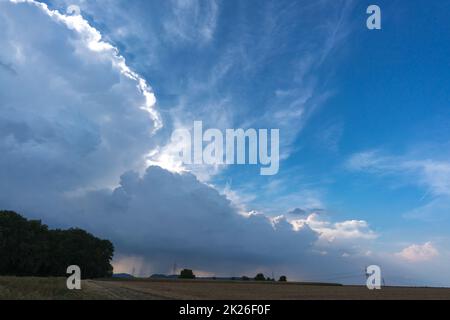 Large storm clouds over the countryside build up and bring wind and heavy rain Stock Photo