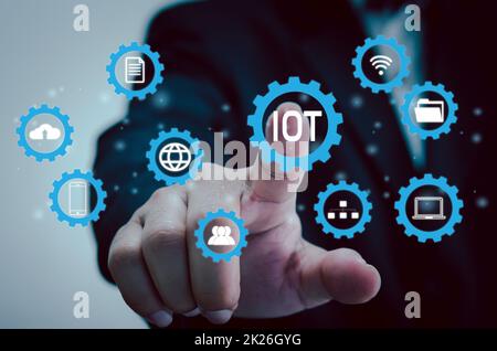 hand press on IOT or internet of things digital technology marketing, global business transformation concept. Stock Photo