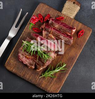 Appetizing medium rare grilled beef steak with baked potato and sauce ...
