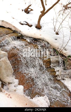 Serene Cascade Rambling Through the Snow Stock Photo