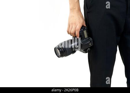 The photographer holds the camera by hand in the hip position. Stock Photo