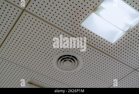 Air conditioner. Air duct and ceiling lamp light mount on ceiling of hospital, hotel, or office building. Cool system in the building. Air flow and ventilation system. AHU air conditioning system. Stock Photo