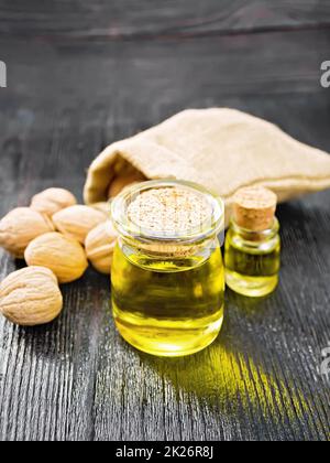 Oil walnut in jar and bottle on black board Stock Photo