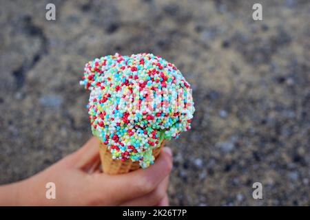 Ice cream with colorful sugar sprinkles in hand as a close-up Stock Photo