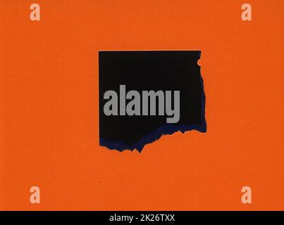 torn orange paper with black hole Stock Photo