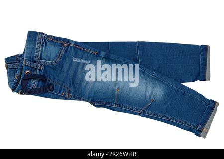 Blue jeans. Closeup of a folded stylish dark blue denim pants or trousers for boys isolated on a white background. Clipping path. Kids summer and autumn fashion. Stock Photo
