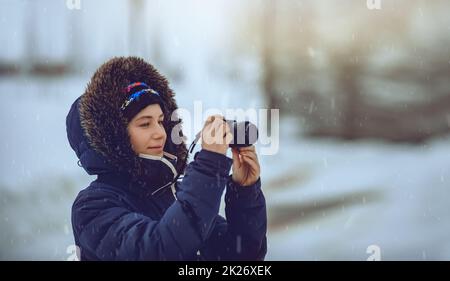 Young Female Taking Pictures in Snowfall Stock Photo