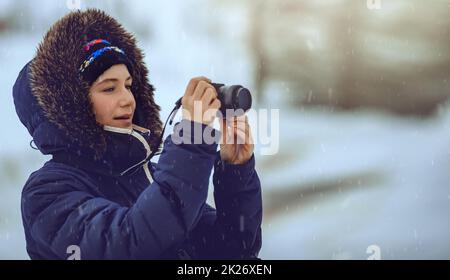 Young Female Taking Pictures in Snowfall Stock Photo