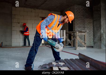 Builder worker with grinder machine cutting metal Stock Photo