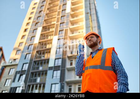 Builder worker using walkie-talkie on construction site Stock Photo