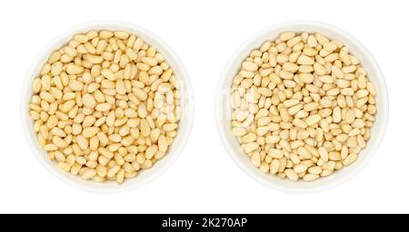 Cedar and pine nuts, also known as pinon or pignoli, in white bowls Stock Photo