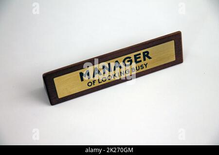 Manager of looking busy wood and metal sign on a white shelf Stock Photo