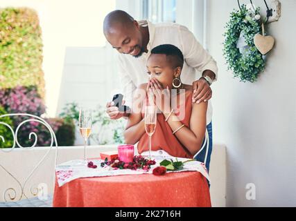 You totally surprised me, babe. Shot of a young man proposing to his his girlfriend on a romantic date. Stock Photo